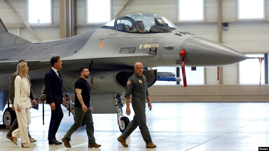 PM Belanda Mark Rutte (ketiga dari kanan) dan Presiden Ukraina Volodymyr Zelenskyy, berjalan di dekat pesawat F-16 di pangkalan udara Eindhoven, Belanda Minggu (20/8). 