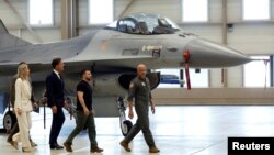 PM Belanda Mark Rutte (ketiga dari kanan) dan Presiden Ukraina Volodymyr Zelenskyy, berjalan di dekat pesawat F-16 di pangkalan udara Eindhoven, Belanda Minggu (20/8). 