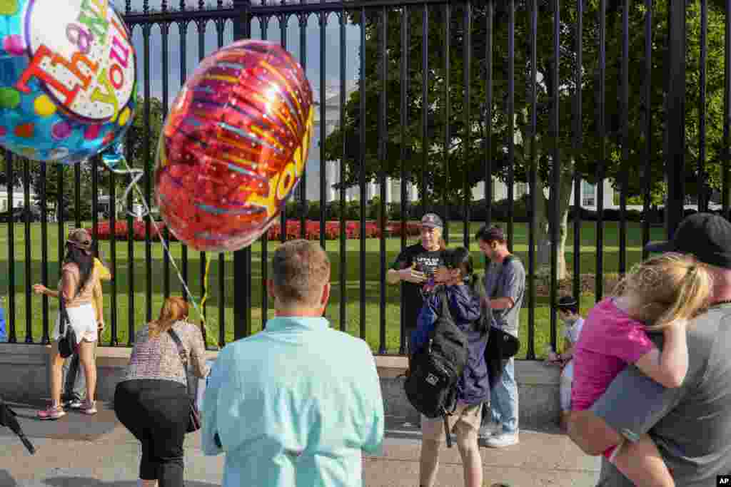 Familias con camisetas y globos con la frase de &quot;Gracias&quot; se acercaron hasta la Casa Blanca a darle ánimo al presidente Biden.