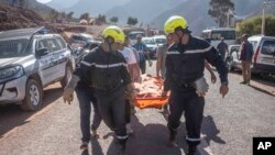 Des secouristes portant le corps d'une victime du séisme dans le village d'Ouargane, près de Marrakesh, le 9 septembre 2023 