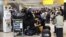 Travelers wait near the British Airways check-in area at Heathrow Airport, as Britain's National Air Traffic Service restricted U.K. air traffic due to a technical issue that caused delays, in London, Aug. 28, 2023. 