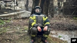 An emergency serviceman sits shocked after a deadly Russian attack in Odesa, Ukraine, in this photo provided by the Ukrainian Emergency Service.