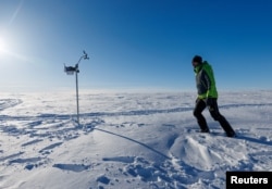 Italian National Research Council geochemist and expedition leader Andrea Spolaor walks along the Ice Memory drilling camp, near Ny-Aalesund, April 10, 2023.