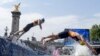 FILE - Athletes dive back into the Seine River for the second lap of the swim portion at the men's individual triathlon competition at the 2024 Summer Olympics, in Paris, France, July 31, 2024. 