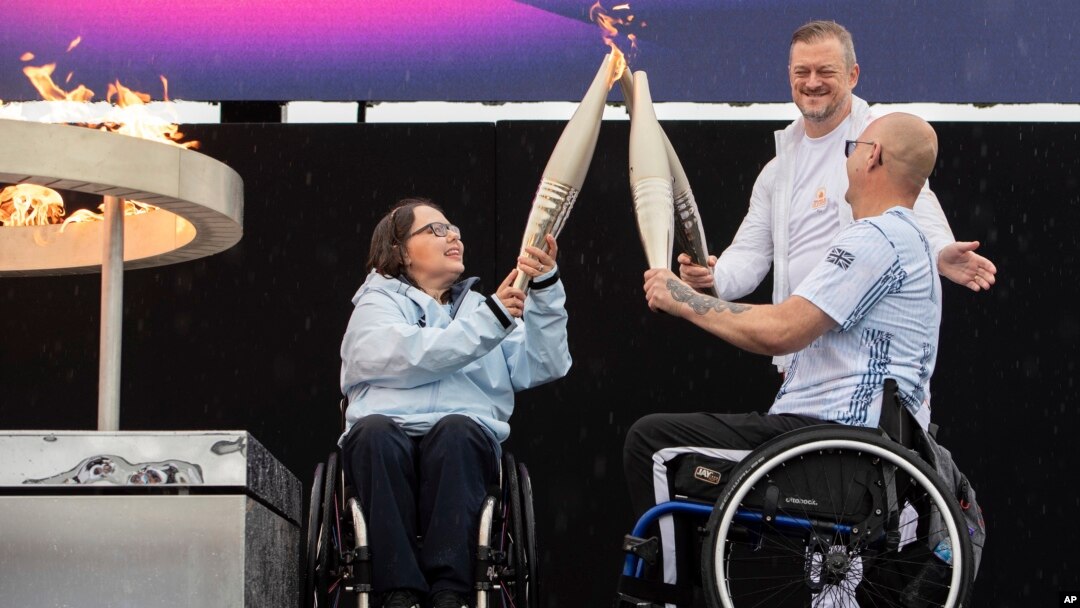 British Paralympians Helene Raynsford, left, and Gregor Ewan light the Paralympic Flame in Stoke Mandeville, widely considered the birthplace of the Paralympic Games, England, Aug. 24, 2024. 