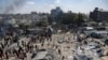 Palestinians inspect the damage at a site hit by an Israeli bombardment on Khan Younis, southern Gaza Strip, July 13, 2024.