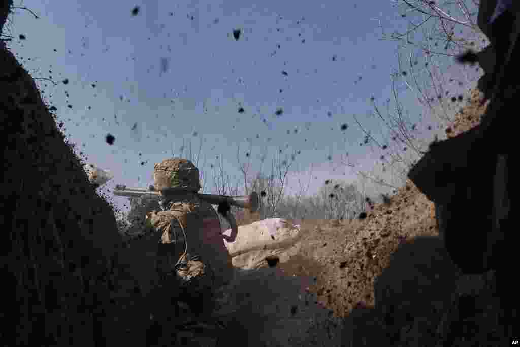 A Ukrainian soldier of the 28th brigade fires a grenade launcher on the front line during a battle with Russian troops near Bakhmut, Donetsk region, Ukraine.