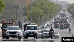 ভারতের আহমেদাবাদের উপকন্ঠে গরম আবহাওয়ায় মধ্যে একটি রাস্তায় যানবাহন চলাচল করছে। ১২ মে, ২০২২। 