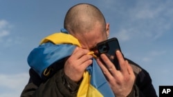 FILE - A Ukrainian prisoner of war cries while calling his relatives after a prisoner exchange on the Ukrainian-Russian border, Jan. 31, 2024. U.N.-backed human rights experts said March 15 they have new evidence of “horrific” torture of Ukrainian prisoners of war.