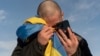 FILE - A recently swapped Ukrainian prisoner of war cries while calling his relatives after a prisoner exchange on the Ukrainian-Russian border, on Jan. 31, 2024. Russian forces are accused of kidnapping and torturing civilians they deem dangerous.