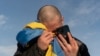 Обмененный украинский военнопленный плачет, звоня своим родственникам после обмена пленными на украинско-российской границе 31 января 2024 года.
