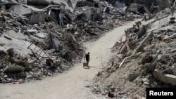 (FILE) A Palestinian walks among the rubble of damaged buildings, which were destroyed during Israel's military offensive, amid the ongoing conflict between Israel and Hamas, in Beit Lahia in the northern Gaza Strip, June 12, 2024.
