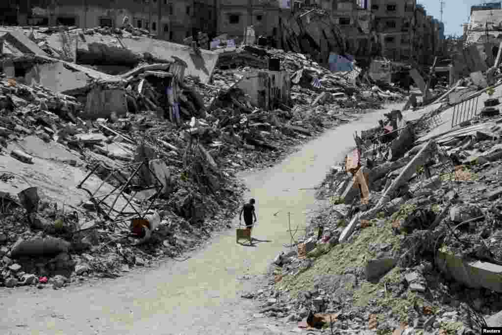 A Palestinian walks among the rubble of damaged buildings, which were destroyed during Israel&#39;s military offensive in Beit Lahia in the northern Gaza Strip, June 12, 2024.