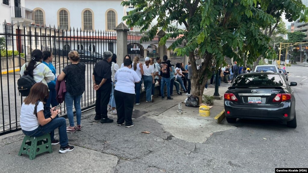 Votantes hacen fila para participar en la elección presidencial venezolana, a las afueras del colegio Santo Tomás de Villanueva, en Caracas, el 28 de julio de 2024.