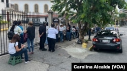 Votantes hacen fila para participar en la elección presidencial venezolana, a las afueras del colegio Santo Tomás de Villanueva, en Caracas.