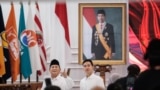 Presiden terpilih Prabowo Subianto dan Gibran Rakabuming Raka berfoto di depan potret Presiden Joko Widodo usai penetapan pemenang pemilihan presiden 2024 oleh KPU, di Jakarta, 24 April 2024. (Foto: Yasuyoshi Chiba/AFP)