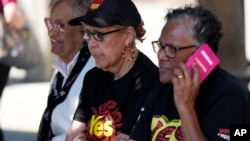 Indigenous women sit at a polling place in Redfern as Australians cast their final votes in Sydney, Oct. 14, 2023, in their first referendum that aims to tackle Indigenous disadvantage by enshrining in the constitution a new advocacy committee. 