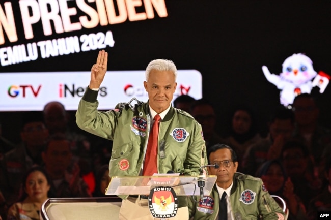 Calon presiden Indonesia sekaligus mantan gubernur Jawa Tengah Ganjar Pranowo saat calon wakil presidennya Mahfud MD (kanan) dalam debat ketiga calon presiden untuk pemilu 2024 di Jakarta, 7 Januari 2024. (ADEK BERRY / AFP)