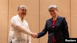 Menteri Luar Negeri Filipina Enrique Manalo dan Menteri Luar Negeri Australia Penny Wong berjabat tangan saat konferensi pers bersama, di sebuah hotel di Makati City, Metro Manila, Filipina, 18 Mei 2023. (REUTERS/Lisa Marie David)