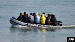 FILE — Migrants are pictured traveling by inflatable boat they reached the shore near Deal on the south east coast of England, after crossing the English Channel from France, on September 14, 2020.