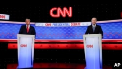FILE - President Joe Biden, right, and Republican presidential candidate former President Donald Trump, left, stand during break in a presidential debate hosted by CNN in Atlanta, Georgia, June 27, 2024.