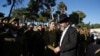 FILE - An ultra-Orthodox Jewish man walks past Israeli soldiers of the Netzah Yehuda Haredi infantry battalion during their swearing-in ceremony in Jerusalem, May 26, 2013. 