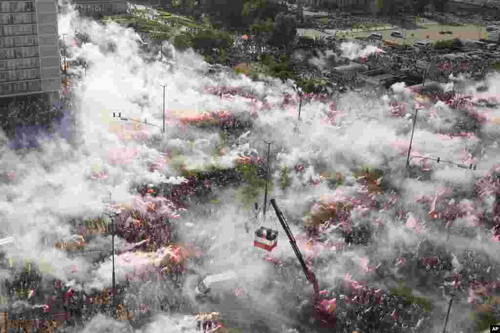 Residents of the Polish capital burn flares in Warsaw to commemorate the 80th anniversary of the outbreak of the Warsaw Uprising during World War II against Nazi German forces.