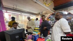 People queue to pay for their products at a supermarket in Khartoum, Sudan, April 26, 2023. The fighting in Sudan has limited food distribution in a nation where a third of the 46 million people relied on humanitarian aid.