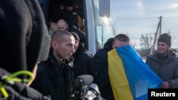 FILE - Swapped Ukrainian prisoners of war disembark from a bus after a prisoner exchange for Russian POWs, at an unidentified location in Ukraine, Jan. 31, 2024. (Ukrainian Presidential Press Service/Handout via Reuters)