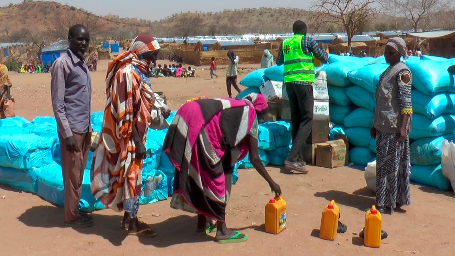 FILE - Sudanese refugees displaced by the conflict in Sudan gather to receive food staples from aid agencies at the Metche Camp in eastern Chad, March 5, 2024. 