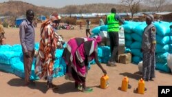 (FILE) Sudanese refugees displaced by the conflict in Sudan gather to receive food staples from aid agencies in eastern Chad, March, 2024. 