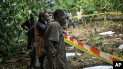 A man looks over the cordon at human remains in a mass grave in Ndoma, near Beni in North Kivu province, Congo, May 6, 2023. The remains of at least 20 people were found over the weekend, according to local authorities and a military spokesperson.