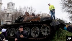 The wreck of a Russian T-72 tank destroyed on the approach to Kyiv is placed in front of the Russian Embassy to mark the first anniversary of Russia's full-scale invasion of Ukraine, in Berlin, Feb. 24, 2023.