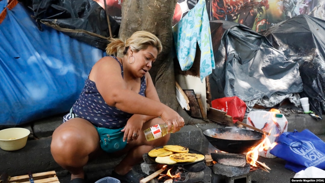 Yuleima Saldeño, una migrante venezolana, prepara arepas en una calle de Ciudad de México, donde espera para seguir su camino hacia Estados Unidos.