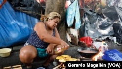 Yuleima Saldeño, una migrante venezolana, prepara arepas en una calle de Ciudad de México, donde espera para seguir su camino hacia Estados Unidos.