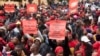 Supporters of the Economic Freedom Fighters (EFF) hold placards as they march through the center in Cape Town on March 20, 2023, during a national shutdown called by their party. 