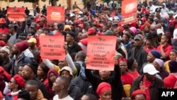 Supporters of the Economic Freedom Fighters (EFF) hold placards as they march through the center in Cape Town on March 20, 2023, during a national shutdown called by their party. 