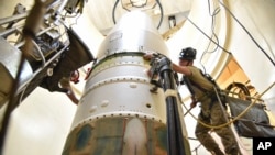 На этом снимке, предоставленном ВВС США, техник проводит обслуживание межконтинентальной баллистической ракеты Minuteman во время имитационного испытания электронного запуска