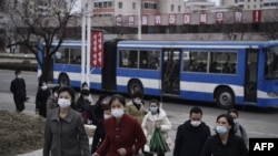 资料照片：2024年3月25日，走在朝鲜平壤凯旋门附近的一条街道上的人们。(法新社照片)