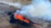 FILE - Lava spurts and flows after the eruption of a volcano in the Reykjanes Peninsula, Iceland, July 12, 2023, as seen in this photo taken from a Coast Guard helicopter.