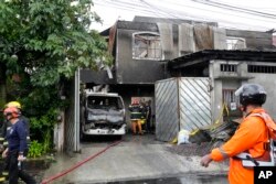 Petugas pemadam kebakaran memeriksa sebuah pabrik yang terbakar di kota Quezon, Filipina, Kamis, 31 Agustus 2023. (AP/Aaron Favila)