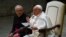 Pope Francis, assisted by Prefect of the Pontifical House, Monsignor Leonardo Sapienza (L), addresses attendees during the weekly general audience, Feb. 15, 2023 at Paul-VI hall in The Vatican.