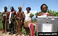 Anggota suku dan perempuan Papua yang mengenakan kostum adat memilih di Jayapura pada 9 Juli 2014 yang terletak di pelosok Provinsi Papua. (Foto: AFP/Liva Lazore)