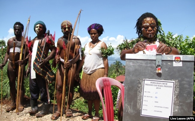 Anggota suku dan perempuan Papua yang mengenakan kostum adat memilih di Jayapura pada 9 Juli 2014 yang terletak di pelosok Provinsi Papua. (Foto: AFP/Liva Lazore)