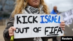 FILE - Seorang penggemar memegang spanduk bertuliskan "Tendang Israel keluar dari FIFA" di luar stadion sebelum pertandingan sepak bola Liga Premier Manchester City melawan Chelsea di Stadion Etihad, Manchester, Inggris, 17 Februari 2024. (REUTERS/Carl Recine)