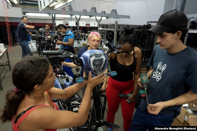 Workers assemble scooters at the Caribbean Electric Vehicles (VEDCA) factory in Havana, Cuba, July 15, 2024. (REUTERS/Alexandre Meneghini)