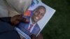 Una persona sostiene una foto del difunto presidente haitiano Jovenel Moise durante su funeral en la casa de su familia en Cabo Haitiano, Haití, el 23 de julio de 2021. Moise fue asesinado el 7 de julio de ese año.