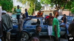 Youths hang out near cars serving as street barricades placed there by residents to deter gangs from entering their neighborhood, in downtown Port-au-Prince, Haiti, May 17, 2024.