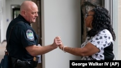 Knoxville Deputy Police Chief Tony Willis talks with Terry Walker-Smith after a meeting of the Violence Reduction Leadership Committee on Thursday, Aug. 3, 2023, in Knoxville, Tenn. (AP Photo/George Walker IV)
