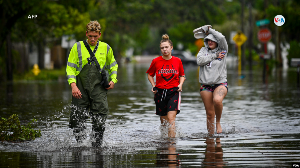 La gente camina por las calles inundadas en New Port Richey, Florida, el 30 de agosto de 2023.